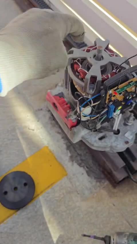 Motor de portão aberto em manutenção, placa e bobina à vista